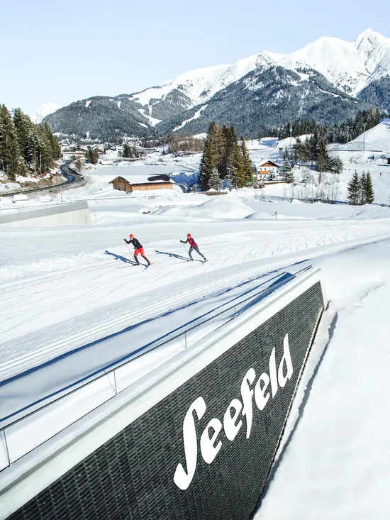 Cross-country skiers on snowy trails in Seefeld with Alpine mountains in background